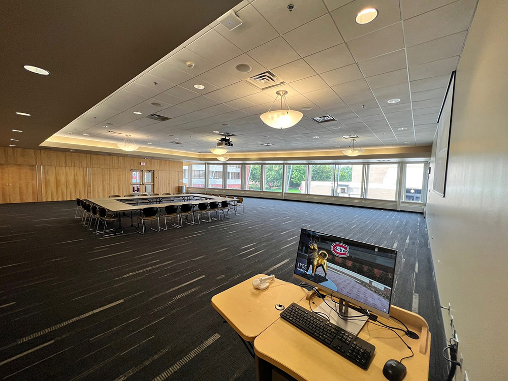 Interior view of the Cascade Room at Atwood Memorial Center showing a small table and chair arrangement with a computer off to the side