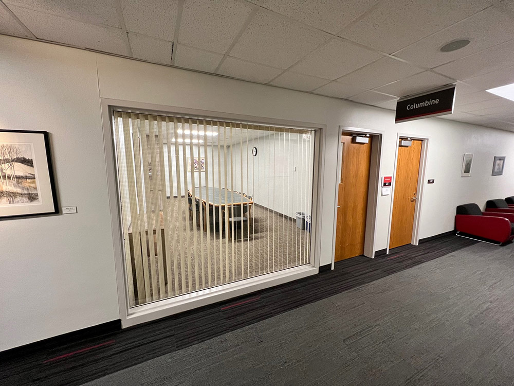 Interior of the Columbine Room at Atwood Memorial Center with round tables and chairs set up, a large window wall letting in natural light, and neutral decor ready for a meeting or reception