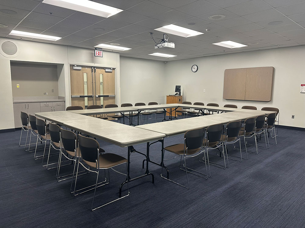Interior of the Glacier South Room at Atwood Memorial Center showing multiple tables arranged together with chairs for a meeting setup