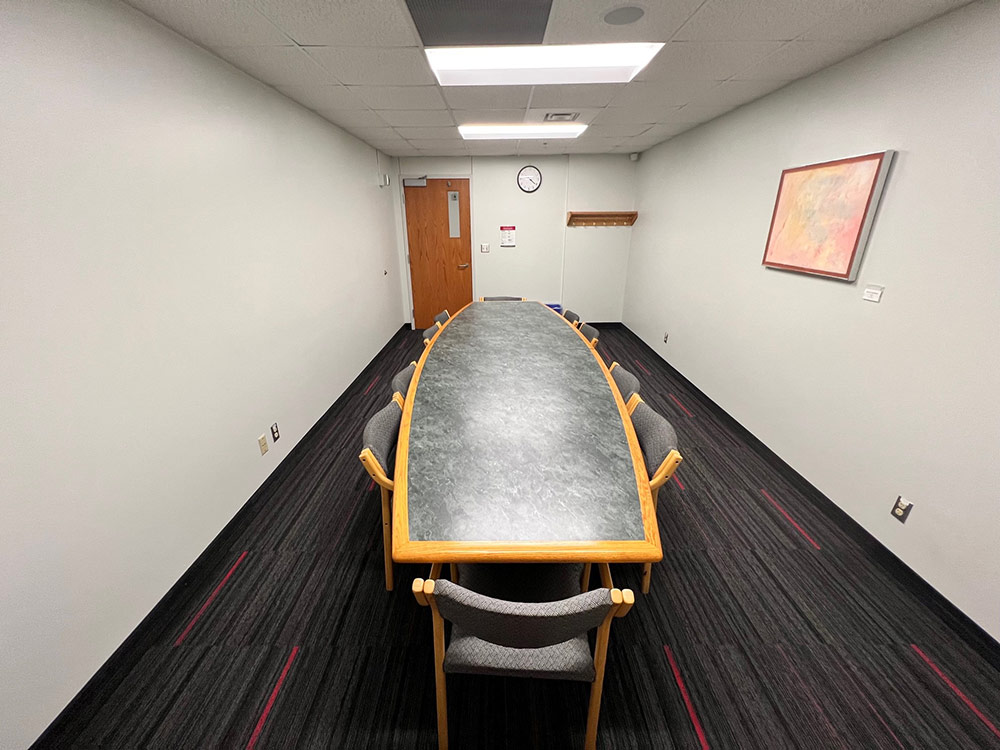 Interior of the Iris Room at Atwood Memorial Center from the center of the room, showing the table and chairs with a clear view to the end of the space