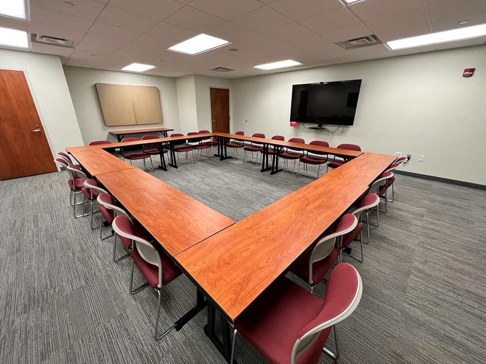 Interior of the Maple Room at Atwood Memorial Center showing a mid-size meeting space with tables and chairs arranged for a group