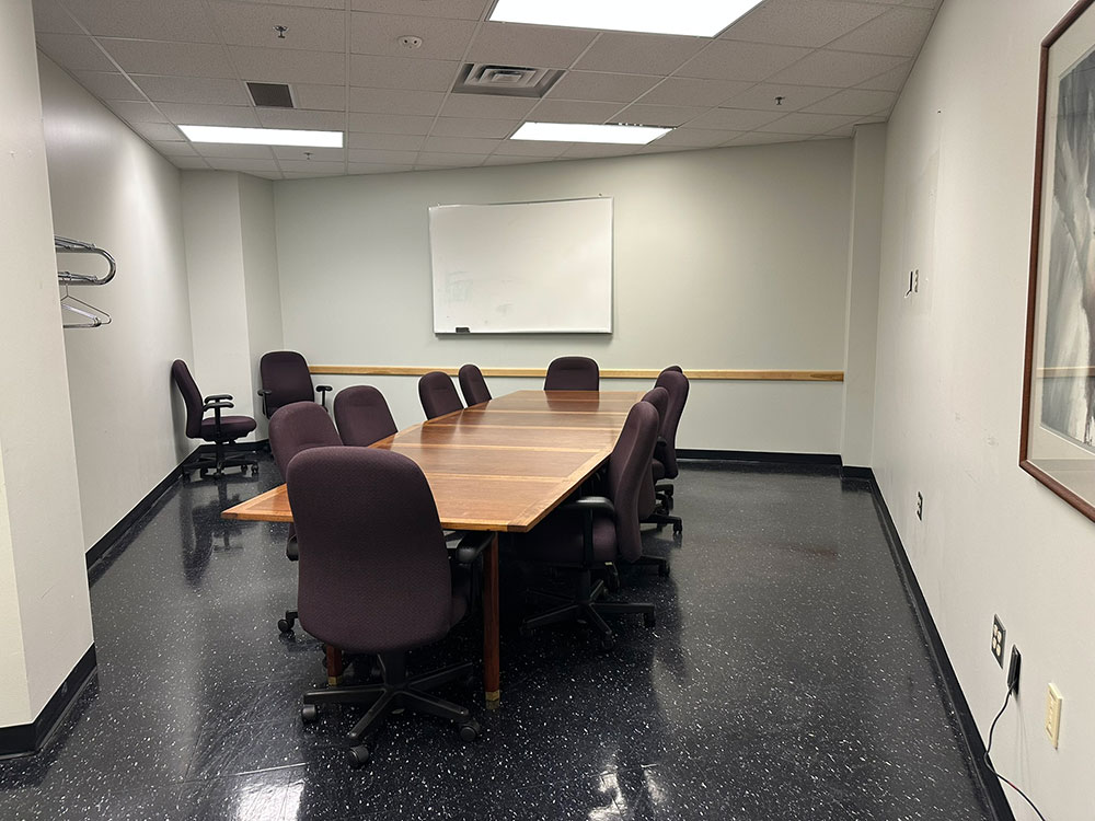 Interior of the M'de Wakan Room at Atwood Memorial Center showing a small meeting space with a boardroom table, chairs, and a whiteboard