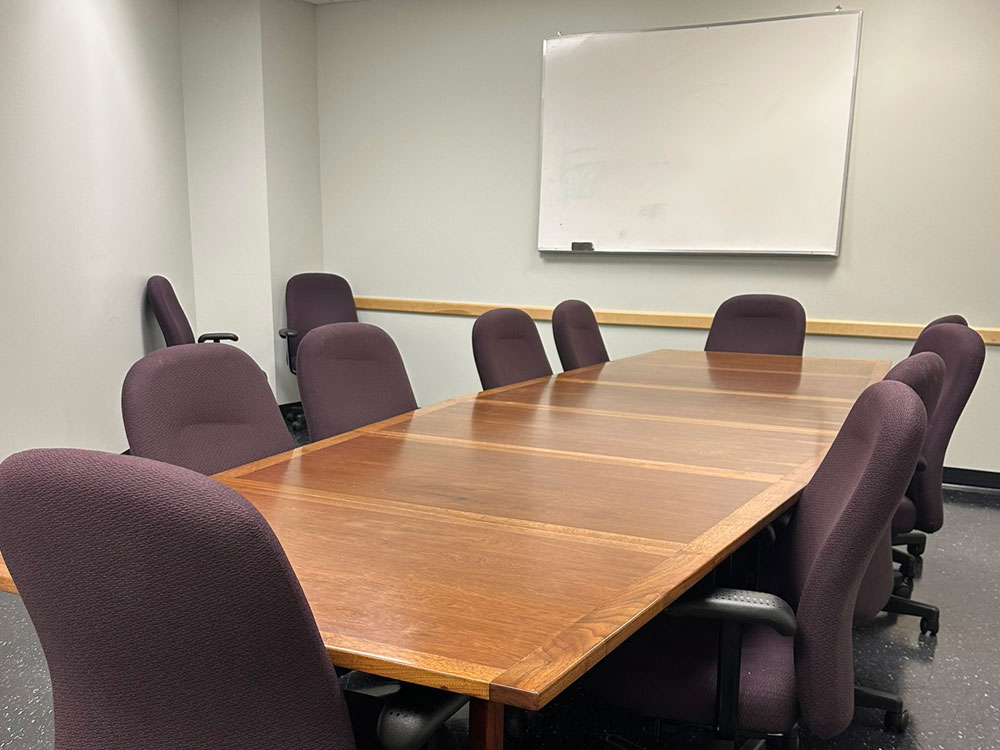 Interior of the M'de Wakan Room at Atwood Memorial Center from a different angle showing the meeting table, chairs, and wall space with a whiteboard