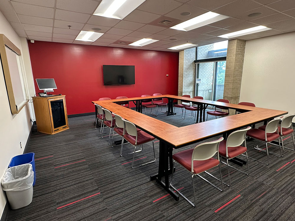 Interior of the Primrose Room at Atwood Memorial Center showing a small meeting space with tables and chairs arranged for a group
