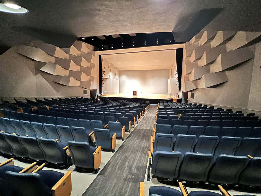 Interior of Ritsche Auditorium in Stewart Hall from the main entrance perspective, showing the seating area and overhead lighting