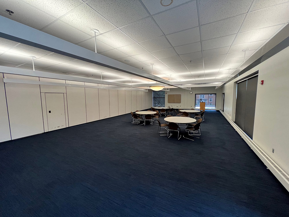 Interior view of the Voyageurs South Room at Atwood Memorial Center showing tables arranged on one end of the room and open space on the other end