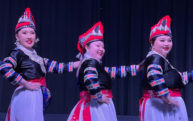 Three students performing a cultural dance during a Cultural Nights event