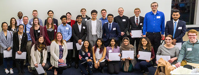 Group photo of math scholarship recipients, with several students holding scholarship certificates