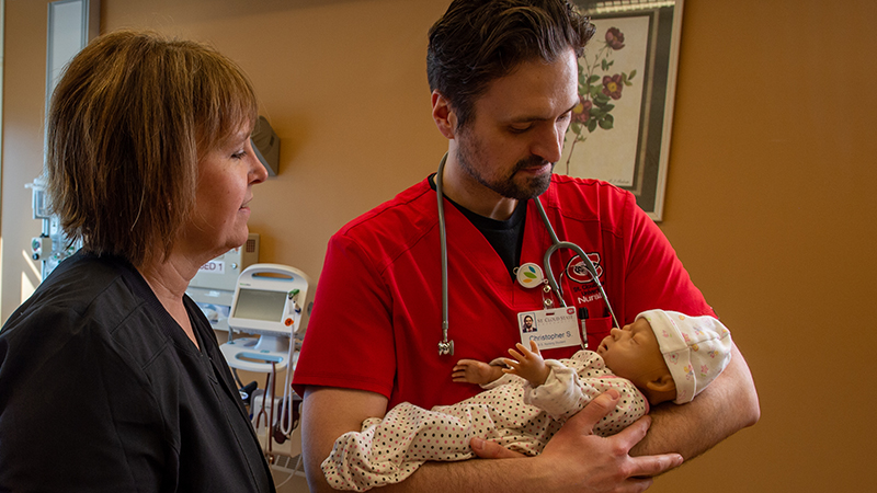 Nursing student practicing infant care skills in a simulation lab